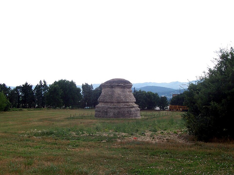 Il nucleo del mausoleo romano della Guastuglia a Gubbio, circondato da un prato